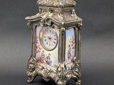 une horloge en argent posée sur une table