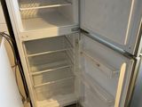 an open refrigerator in a small kitchen with no door