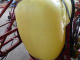 a yellow tank sitting on a red cart in a warehouse