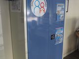 a blue refrigerator with stickers on it in the corner of a room