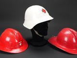 three red hard hats sitting next to each other on a mannequin head