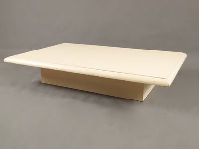 une image représentant une table basse blanche sur fond gris