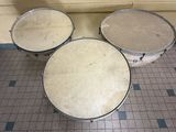 three drums sitting on a tiled floor in a room