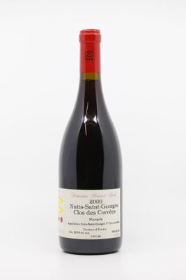 the bottle of red wine is sitting on a white surface