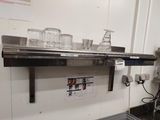 une étagère en métal sur laquelle sont posés des verres, dans une cuisine