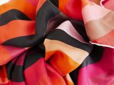 multicolored silk scarf on white background with black and orange stripes