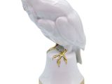 white owl figurine on gold base with white background