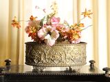 a vase with flowers in it on top of a piano