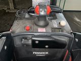 a red and black snow blower sitting in a garage
