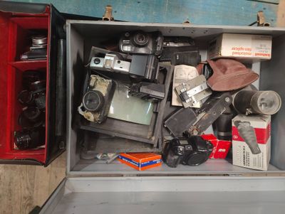 a metal box filled with old cameras and other items