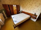 an image of a bedroom with a bed and a dresser