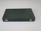a black box with gold handles sitting on a white surface