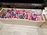 a wooden box filled with lots of pink and purple items