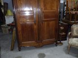 une grande armoire dans une pièce où se trouvent une chaise et une chaise