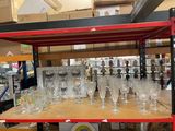 de nombreux verres à vin vides sur une étagère dans un magasin