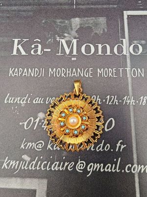 une photo d'un pendentif en or serti d'une perle