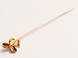 broche en forme de fleur dorée sur fond blanc