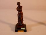 une statue en bronze représentant une femme tenant une raquette de tennis