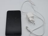 a cell phone and a charger on a white table