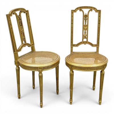 une paire de chaises dorées avec des assises en rotin et une assise en rotin