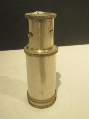 un petit briquet argenté posé sur une table blanche