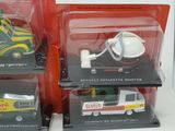 three toy vehicles in the packaging on the table