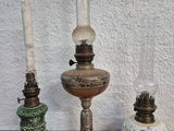 Trois lampes à huile anciennes sont posées sur un plan de travail en marbre