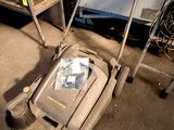 a lawn mower sitting on the floor in a garage