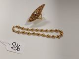 un gros plan d'un collier et d'une bague posés sur une surface blanche