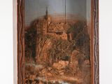 une vieille photo représentant un tableau représentant un château, dans un cadre en bois
