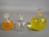three bottles of perfume sitting next to each other on a table