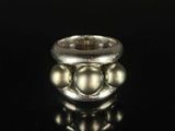 a close up of a silver ring on a black surface