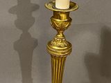 pair of antique brass candlesticks with candles on each of them