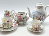 trois tasses et soucoupes, sur lesquelles sont posées une théière et une soucoupe