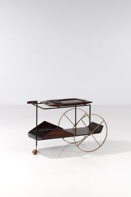 un chariot noir et doré muni de roulettes, posé sur une surface blanche