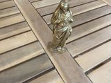 une figurine en or posée sur une table en bois