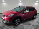 une voiture rouge est garée dans une pièce au sol en damier