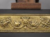an image of a gold plaque with a picture of a man and a woman riding horses