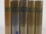 quatre livres sont alignés sur une surface blanche