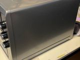 a silver microwave sitting on a table in a room