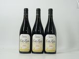 trois bouteilles de vin sont posées sur une surface blanche