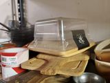 a wooden cutting board on a kitchen counter with bowls and pans on it