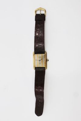 a brown leather watch with a gold buckle on a white background