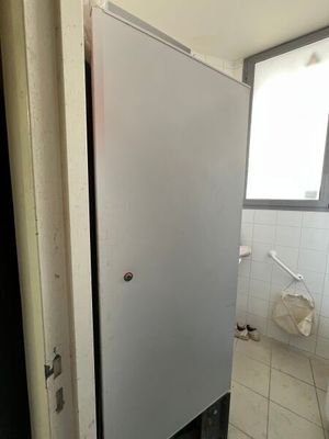a refrigerator that is in the corner of a bathroom