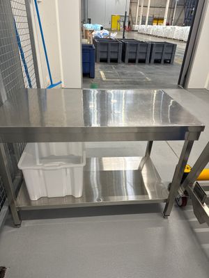une table en acier inoxydable au milieu d'une pièce