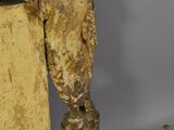 statue of a man leaning on a box with a bird perched on it