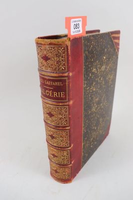 un vieux livre à la couverture rouge posé sur une surface blanche
