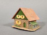 a small model of a house with a green roof