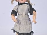 a small doll that is standing on a white surface