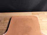 un morceau d'argile posé sur une table en bois, sur fond noir